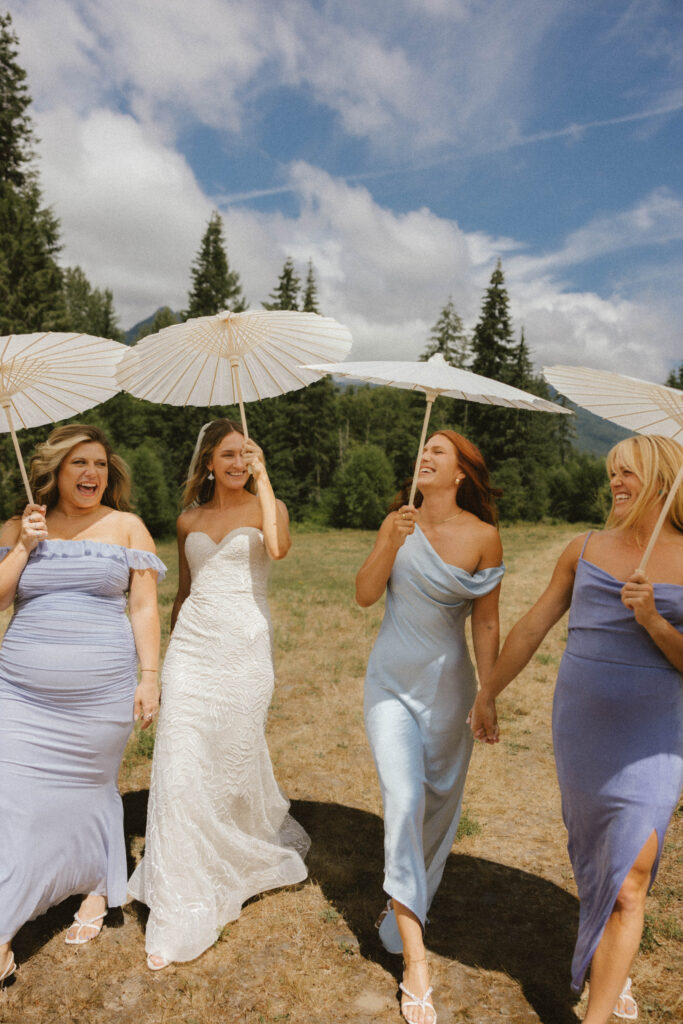 editorial shot of bride and bridesmaids with umbrellas and colorful dresses.