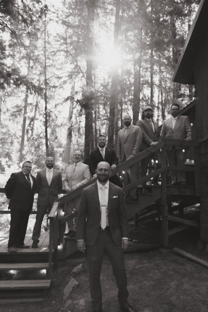 groom with all of his groomsman in the mountains outside of a cabin.