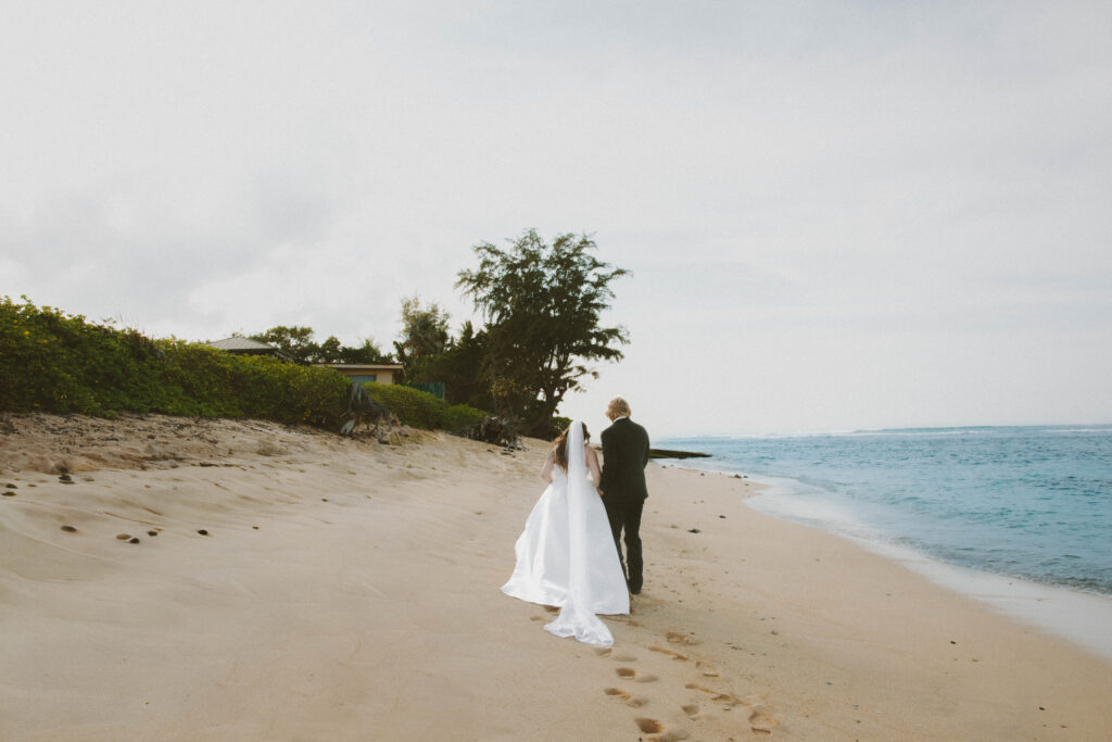 bride and groom walking on the beach on oahu hawaii